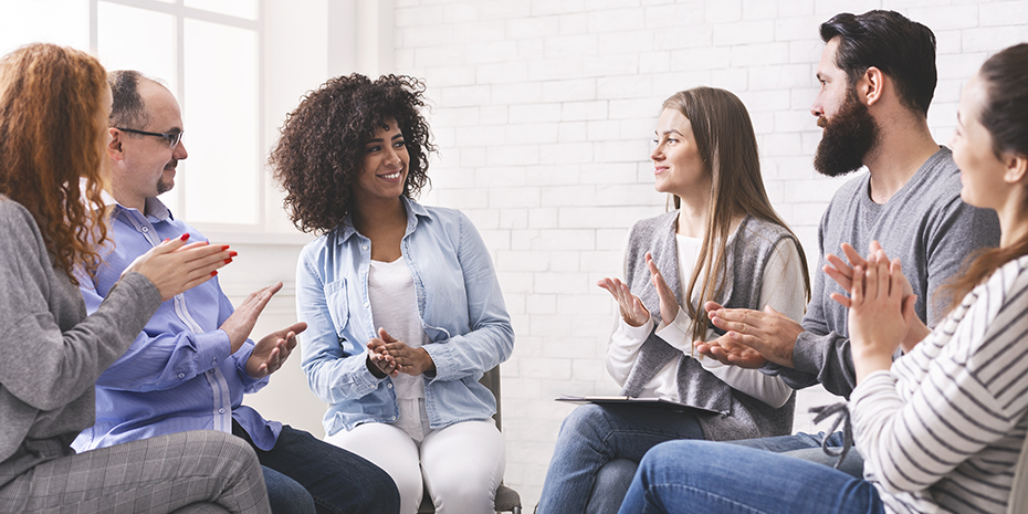 Diverse people applauding to themselves at therapy session in rehab.